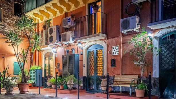 A building with multiple balconies, air conditioning units, and potted plants. - Suite with a Balcony at the Teatro Massimo (Catania)
