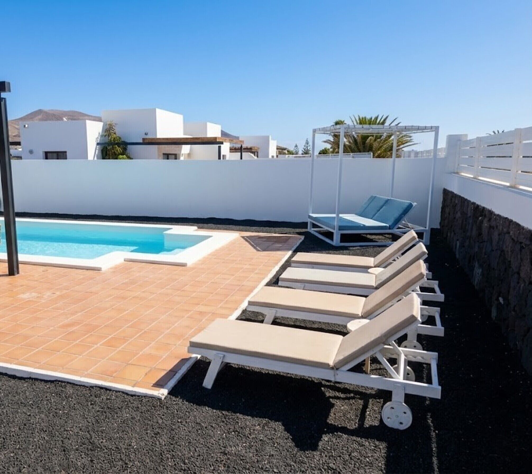 A rooftop pool area with lounge chairs and a swimming pool.