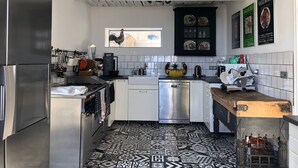 A modern kitchen with a stainless steel refrigerator, a dishwasher, and a wooden countertop.