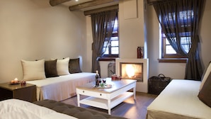 Une pièce confortable avec un lit, un canapé, une table basse et une cheminée.