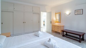 A hotel room with a large bed, a wooden bench, a dresser, and a mirror. - Villa Sevilla Private Pool by Casasol (Nerja)