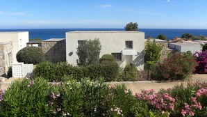 Zona residencial costeira com edifícios modernos, céu azul límpido e vista para o mar.