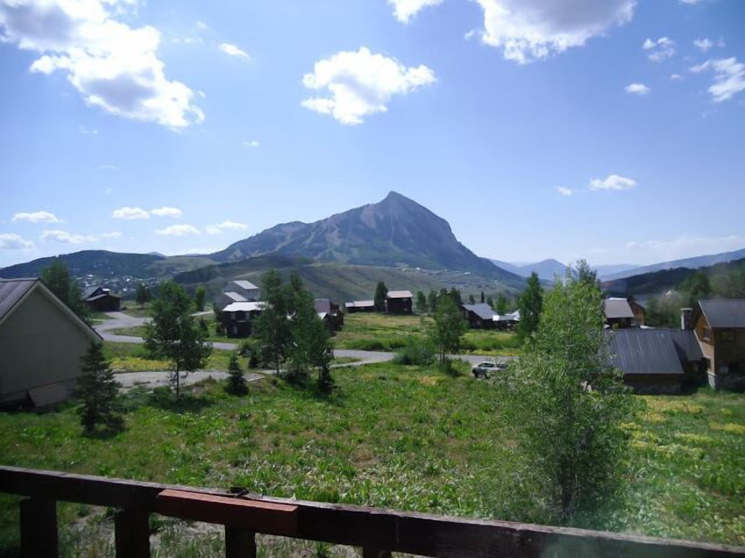 Un village rural avec des maisons et une montagne en arrière-plan.