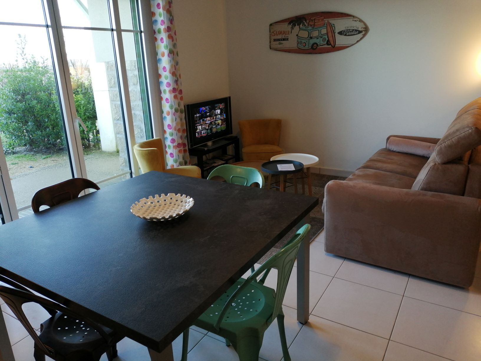 Un espace repas comprenant une table, des chaises, un téléviseur et un canapé.