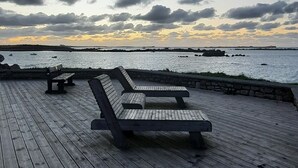 A wooden deck with benches overlooking a body of water.