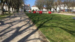 Puisto, jossa on kivimurskapolku, vihreää ruohoa ja punaisia, pallomaisia veistoksia.