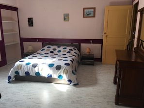 A bedroom with a bed, two bedside tables, a nightstand, a wooden dresser, a door, and a wall with a picture. - Large apartment downtown, quiet, comfortable, free tea, coffee (Dole)