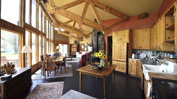 A spacious kitchen with wooden cabinets, a large island, and a stone fireplace. -  Gorgeous Pet-friendly Boutique Ranch ! Next to  skiing, fishing, rafting  (Snowmass)