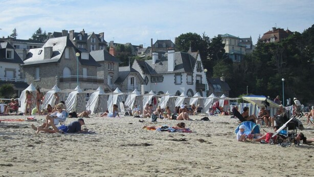 Een strand met tenten en mensen.