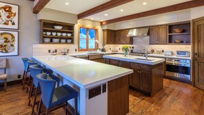 A spacious kitchen with a large island, wooden cabinets, and a built-in oven. -  5 Bed/5.5 Bath Ski-in Ski-out Lodge on Granite Ridge (Jackson)
