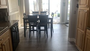 A kitchen with a dining area, wooden cabinets, and a chandelier. - Experience lake life at our 3-bedroom beachfront cottage, near Grand Rapids. (Rockford)