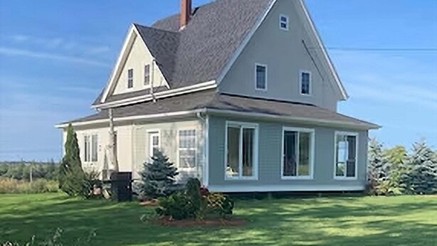 A two-story house with a gabled roof, a front porch, and a well-maintained lawn. - Charming 4 Bedroom Country House - 10 km from Summerside -  (Miscouche)