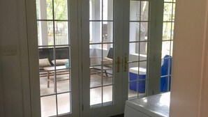 A room with a tiled floor, a washing machine, and a trash can. - 1 block to the beach, easy stroll to town.Screened porch, private yard, fire pit (Union Pier)