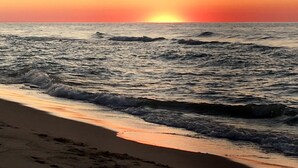 A beach with waves at sunset. - 1 block to the beach, easy stroll to town.Screened porch, private yard, fire pit (Union Pier)