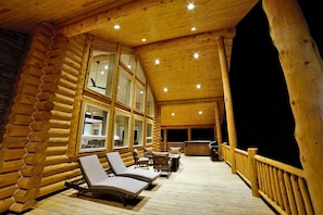 En hytte med veranda, liggestole og jacuzzi.
