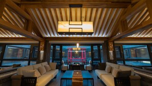 A spacious lounge area with a wooden ceiling, large windows, and a central seating arrangement. - LiuHeYunYan Hotel.Dali (Dali)