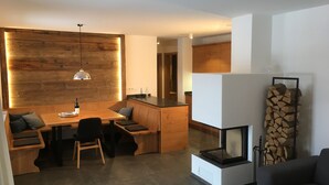 Una cocina moderna con detalles de madera, un comedor con banco y una chimenea.