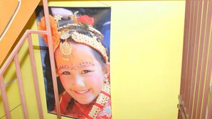 Pared amarilla con un cuadro de una persona vestida con atuendo tradicional.