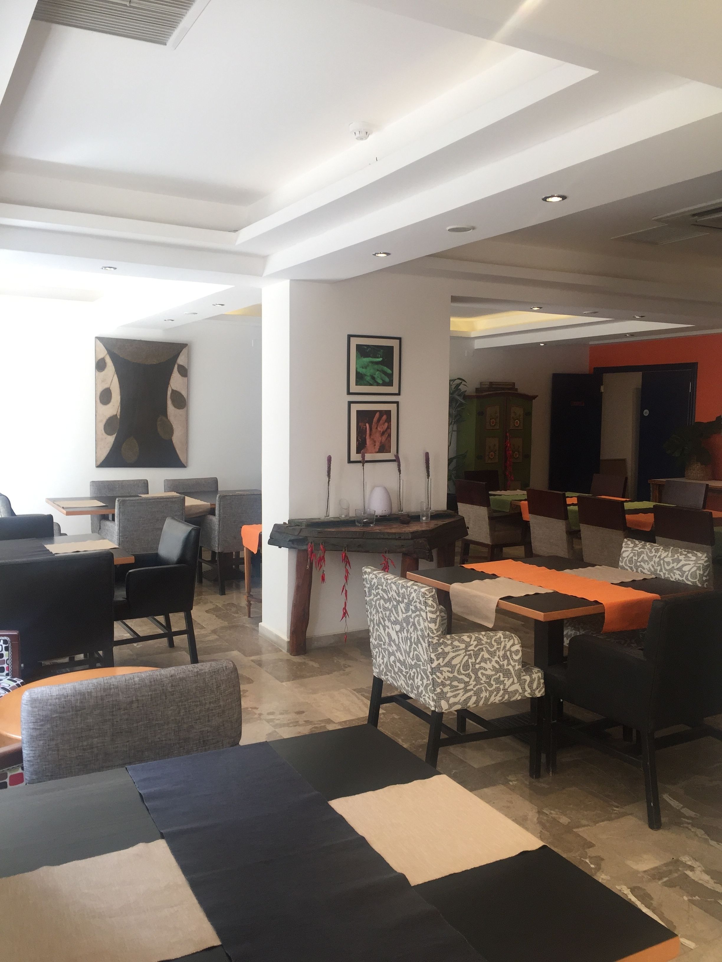 A spacious lobby with modern furniture, a central coffee table, and a seating area with patterned chairs.