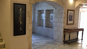 A hallway with a stone archway, a marble floor, and a framed picture on the wall. - Guest House Amman (Amman)