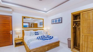 A bedroom with a wooden bed, bedside tables, a wardrobe, a mirror, and a framed picture on the wall. - Secret Outlook Lembongan (Lembongan Island)