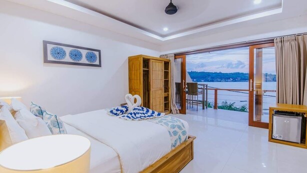 A bedroom with a bed, a desk, and a view of the sea. - Secret Outlook Lembongan (Lembongan Island)