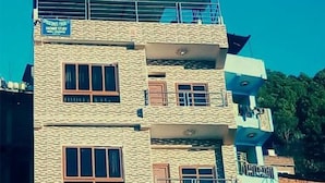 A multi-story building with a sign indicating "Home Stay." - Natures Treat Homestay (Tansen)