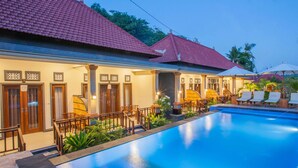 A hotel with a swimming pool, wooden furniture, and a red-tiled roof. - Kastapar Bridge Guest House (Lembongan Island)
