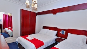 A hotel room with two beds, a wooden wardrobe, a mirror, and a chandelier. - Brentwood Villa Bed and Breakfast (Aberdeen)