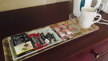 A tray with tea packets, a glass, and a white mug on a wooden table.