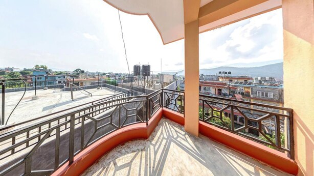 Balcón con vistas a un paisaje urbano, que incluye edificios y depósitos de agua.