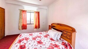 Un dormitorio con cama de madera, ventana con cortinas y ventilador de techo.