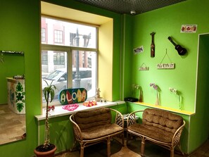 Relax in a room with a vibrant atmosphere, featuring a street view, wicker chairs, and eclectic decor.