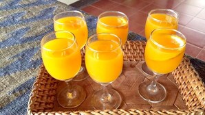 Uma bandeja com seis copos de sumo de laranja sobre um tapete tecido.