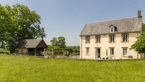 Ein großes, zweistöckiges Haus mit Satteldach und einem kleinen Anbau.