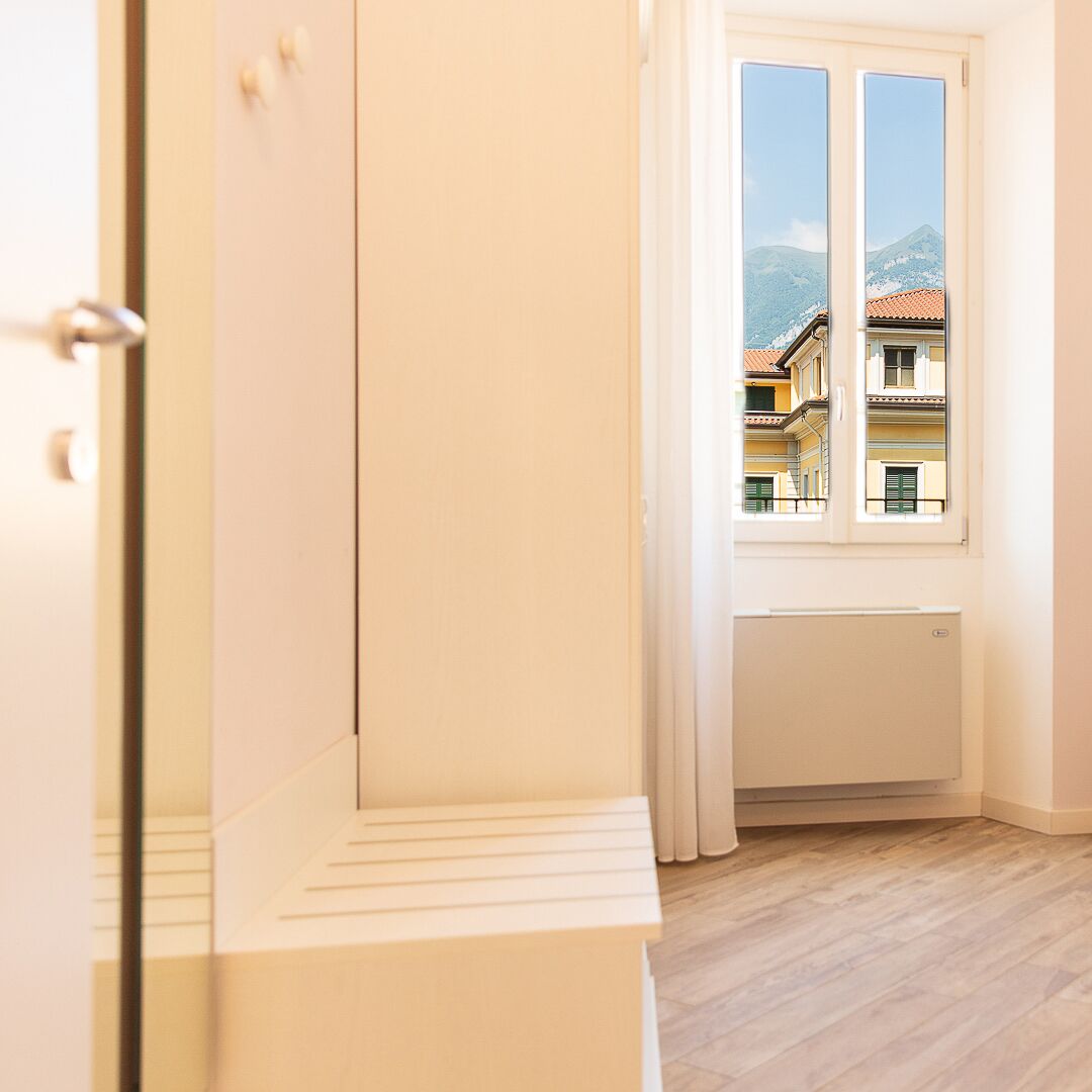 Una habitación con ventana, radiador y puerta.