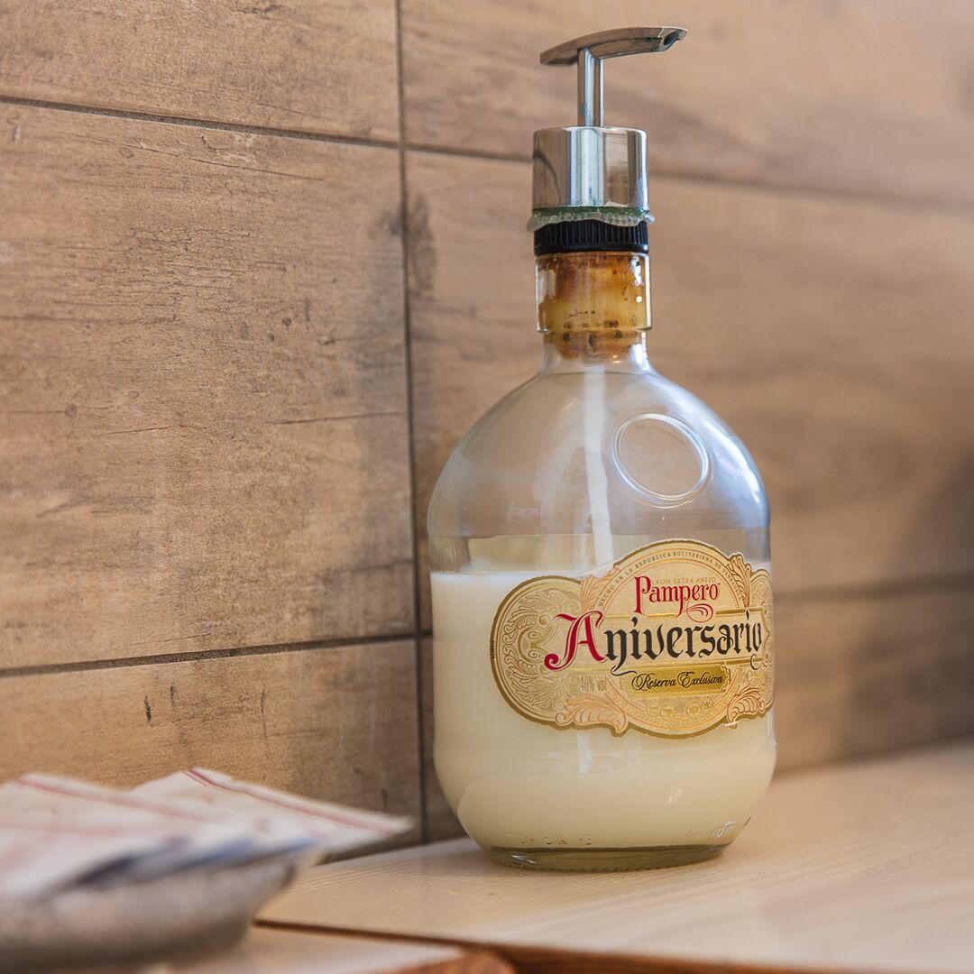 A bottle of Pampers Anniversary baby lotion on a wooden surface.