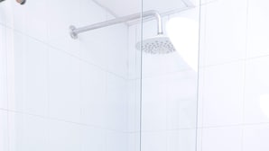 A glass-enclosed shower with a handheld showerhead and two wall-mounted faucets. - Hayuelos  Apartamentos Cerca al Aeropuerto el Dorado (Bogotá)