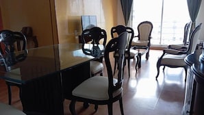 A dining area with a glass table and chairs, a television, and a view of the outdoors. - Hayuelos  Apartamentos Cerca al Aeropuerto el Dorado (Bogotá)