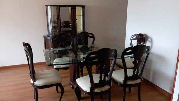 A dining area with a glass table surrounded by four chairs with cushioned seats. - Hayuelos  Apartamentos Cerca al Aeropuerto el Dorado (Bogotá)