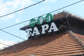 A sign with the word "TAPA" and symbols indicating a bed, a fork and knife, and a bottle.