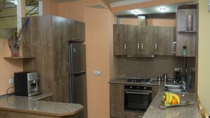 A compact kitchen with a built-in oven, a coffee machine, and granite countertops.