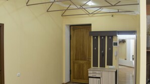A hallway with a wooden door, a small cabinet, and a mirror on the wall.