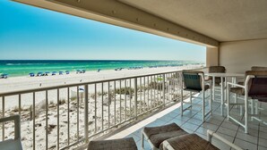 Ein Balkon mit Blick auf Strand und Meer.