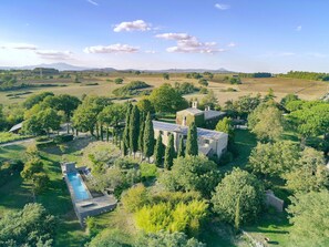Una extensa propiedad con piscina, varias edificaciones y abundante vegetación.