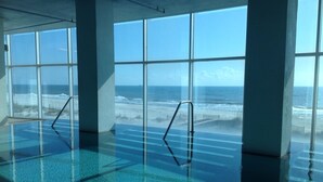 A large indoor swimming pool with clear views of the ocean through large windows. - 22nd Floor Beachfront Suite - Amazing Views (Gulf Shores)