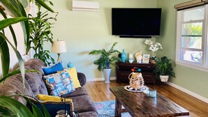 A living room with a sofa, coffee table, and potted plants. - Quaint and Charming 2 bd, 1 bath,  Central Location, easily accessible! (San Diego)