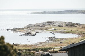 A coastal landscape with rocky terrain, a small body of water, and a dock. - Johanna's Hotel (Bua)