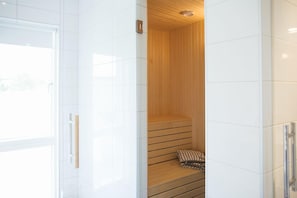 A modern sauna with a wooden bench and a small pillow. - Johanna's Hotel (Bua)