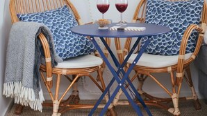 A room with two wicker chairs, a small table, and a potted plant by the window. - Johanna's Hotel (Bua)
